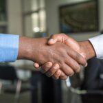 Close-up of two men's handshake symbolizing agreement in an office.